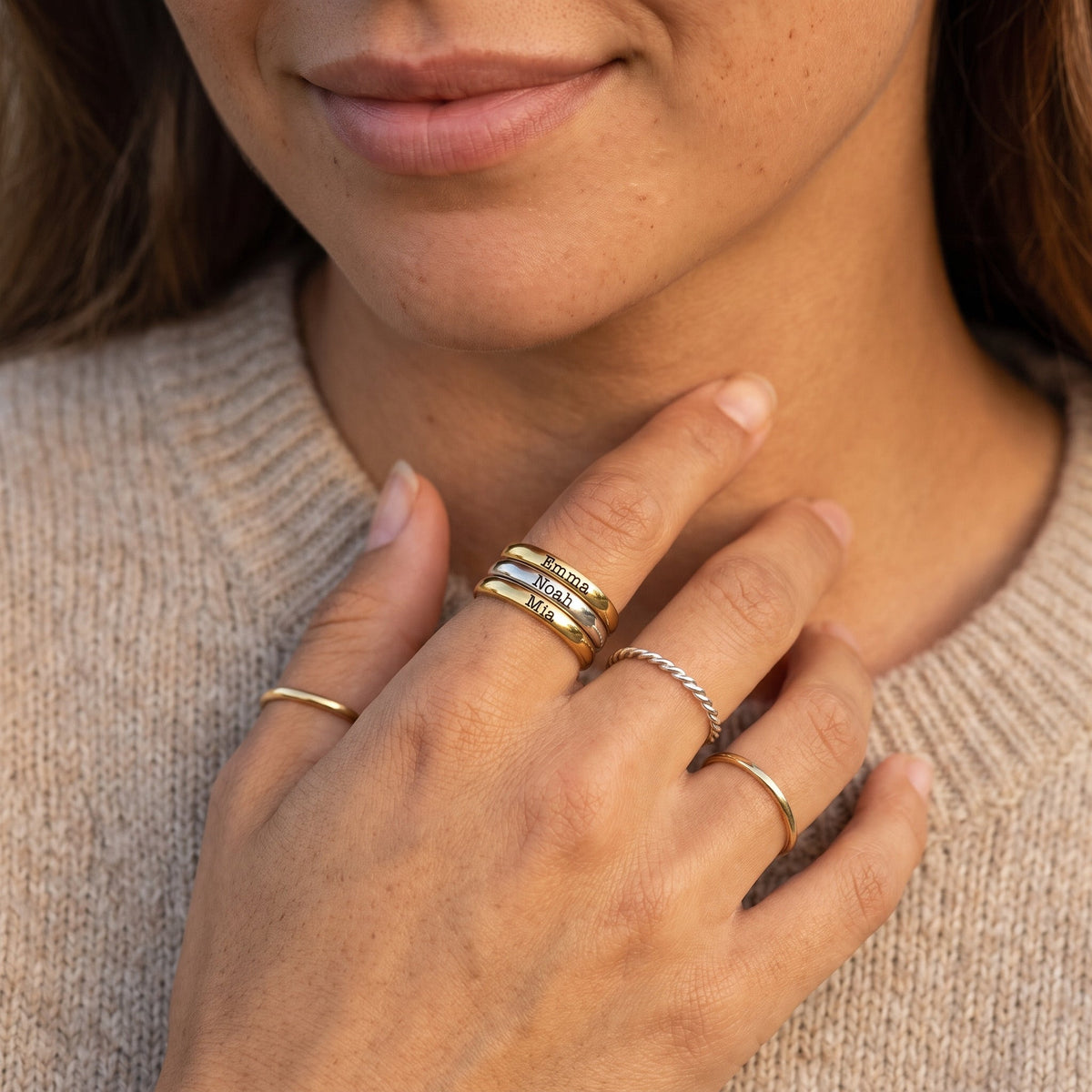 Bague fine empilable avec prénom – or & argent – associée à d’autres bagues, portée