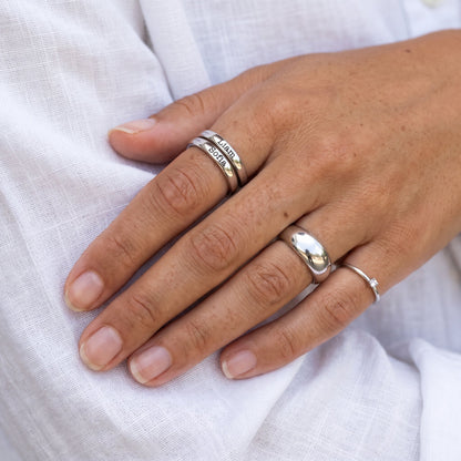 Bague fine empilable avec prénom – argent – associée à d’autres bagues, portée, gros plan